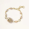 Gold-plated bracelet with pink baroque pearl centerpiece, floral connector, and freshwater pearls