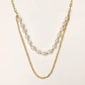 Layered gold chain necklace with organic baroque freshwater pearls and adjustable length on cream background
